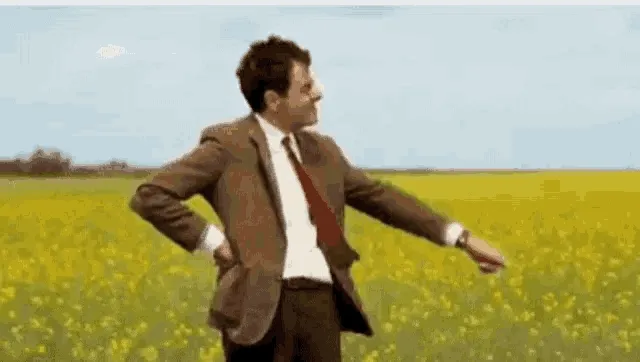 Mr Bean turning impatiently on the spot in a field, waiting